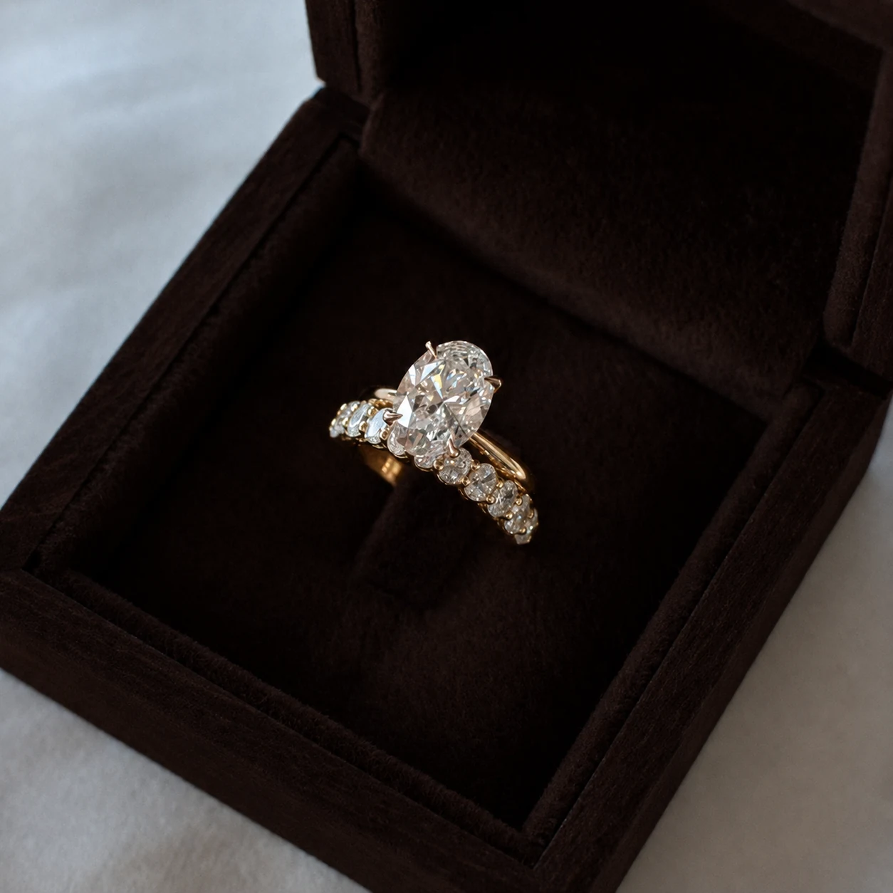 LILY DIA oval diamond engagement ring and matching diamond band in a brown ring box